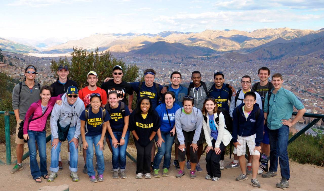 Students and faculty posing in front of mountains on trip